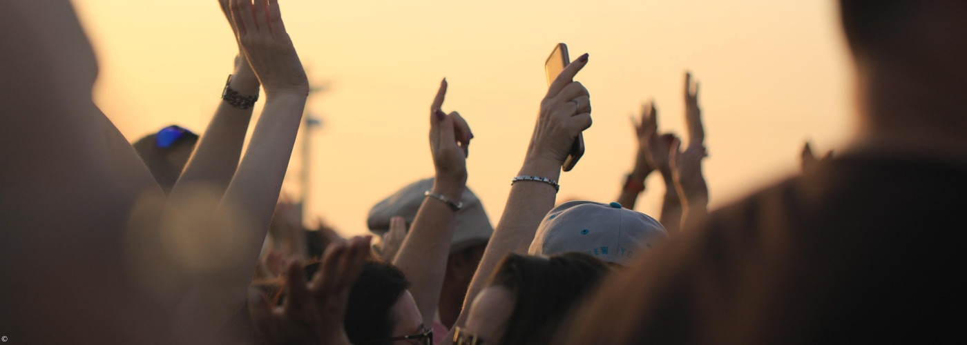 Menschen, die ihre Hände feiernd nach oben recken
