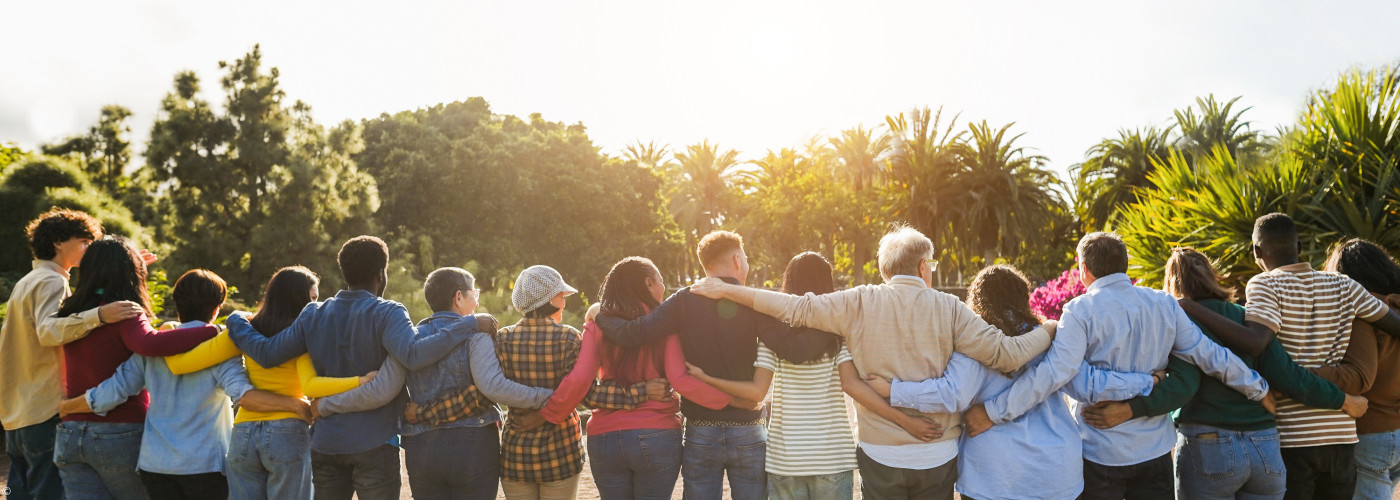 Junge Menschen, die sich an den Schultern halten und nebeneinander stehen